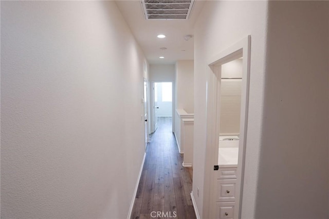 hallway with baseboards, hardwood / wood-style floors, visible vents, and recessed lighting