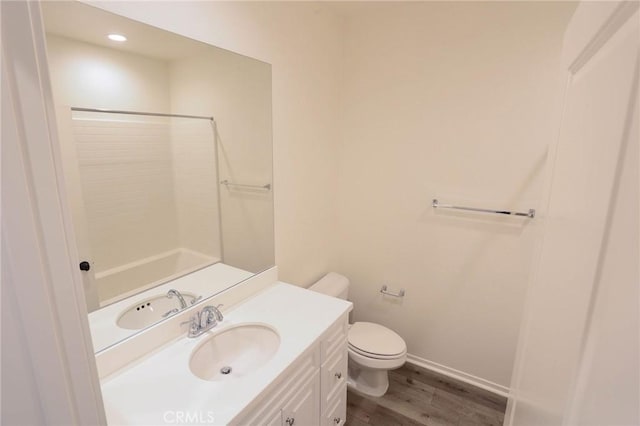 full bathroom with walk in shower, wood finished floors, toilet, and vanity
