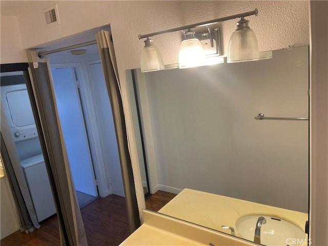 600 W 9th St Unit 902, Los Angeles, CA 90015 - bathroom featuring stacked washing machine and dryer and wood finished floors