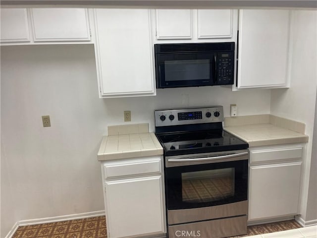 600 W 9th St Unit 902, Los Angeles, CA 90015 - kitchen featuring black microwave, electric range, tile countertops, and white cabinets