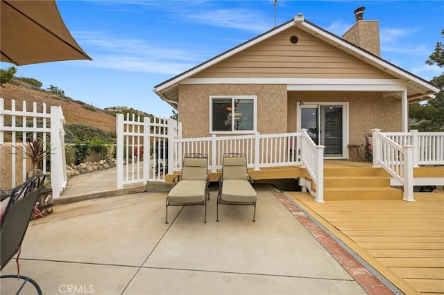 33435 Hubbard Rd, Acton, CA 93510 - back of property with stucco siding, a wooden deck, a chimney, and a patio