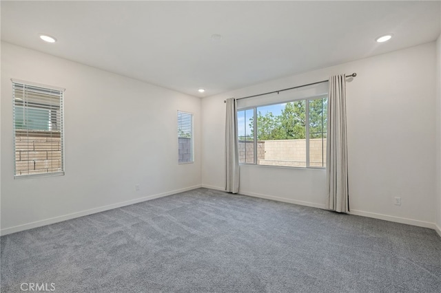 carpeted empty room featuring baseboards and recessed lighting