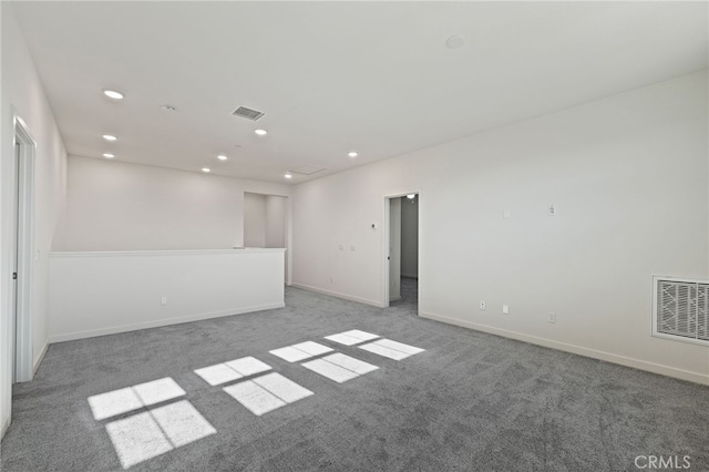 empty room with carpet flooring, recessed lighting, visible vents, and baseboards