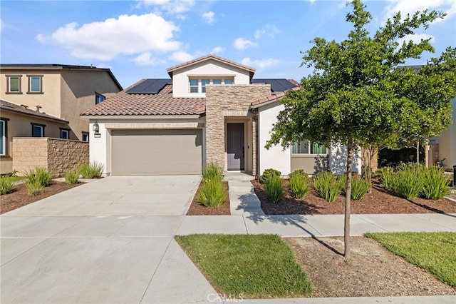 mediterranean / spanish-style house featuring stucco siding, a garage, a tile roof, roof mounted solar panels, and concrete driveway