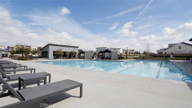 community pool with a patio and a residential view