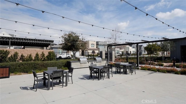 view of patio with an outdoor kitchen, fence, and outdoor dining area