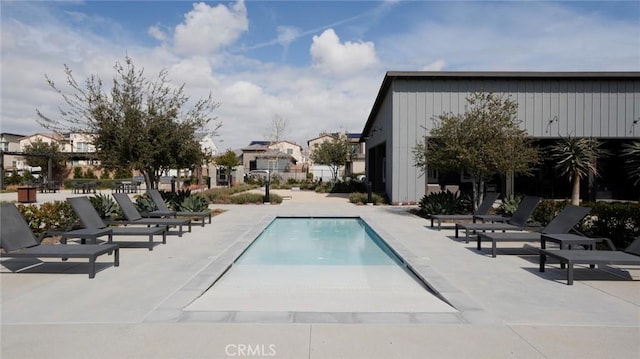 community pool featuring a patio area and a residential view