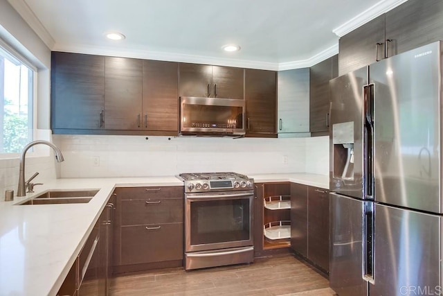 13522 Utopia Rd, Poway, CA 92064 - kitchen featuring appliances with stainless steel finishes, decorative backsplash, light countertops, light wood finished floors, and dark brown cabinetry