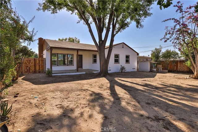 back of property with fence and stucco siding