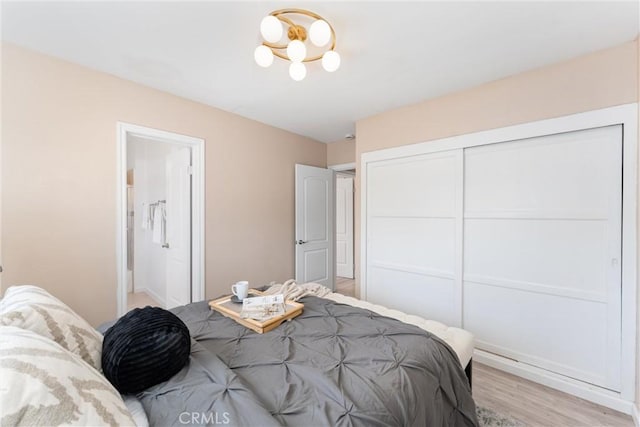 bedroom with light wood-style flooring and a closet