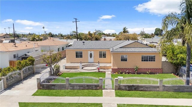view of front of home with a fenced front yard, a residential view, a front lawn, and stucco siding