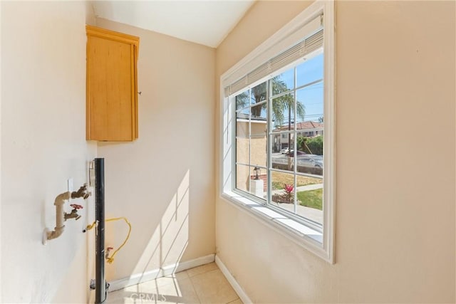 doorway to outside with baseboards and light tile patterned floors
