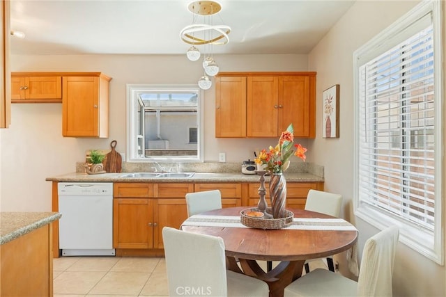 kitchen featuring dishwasher, light countertops, a sink, and light tile patterned flooring