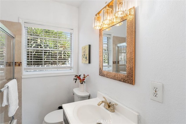 bathroom featuring toilet, a notable chandelier, a stall shower, and a wealth of natural light