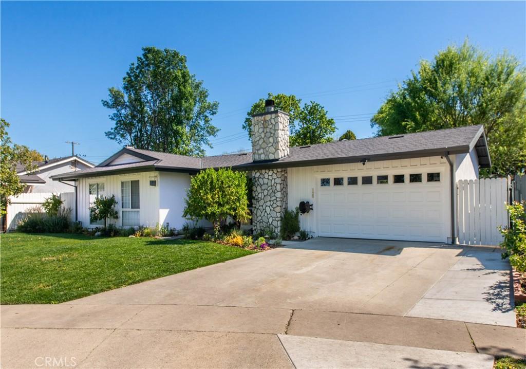 9510 Laramie Ave, Chatsworth, CA 91311 - single story home featuring a chimney, driveway, board and batten siding, an attached garage, and a front yard
