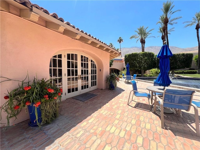 500 E Amado Rd Unit 420, Palm Springs, CA 92262 - view of patio / terrace featuring french doors, a mountain view, and a swimming pool