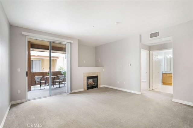 24909 Madison Ave Unit 1311, Murrieta, CA 92562 - unfurnished living room featuring a tiled fireplace, baseboards, carpet flooring, and visible vents