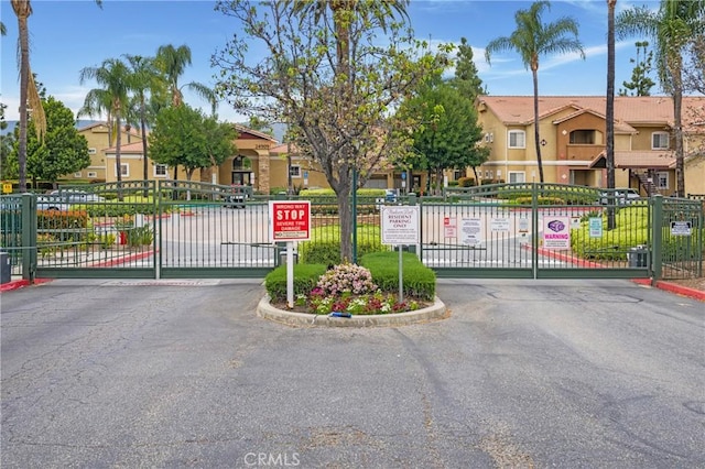 24909 Madison Ave Unit 1311, Murrieta, CA 92562 - view of gate featuring a residential view and fence