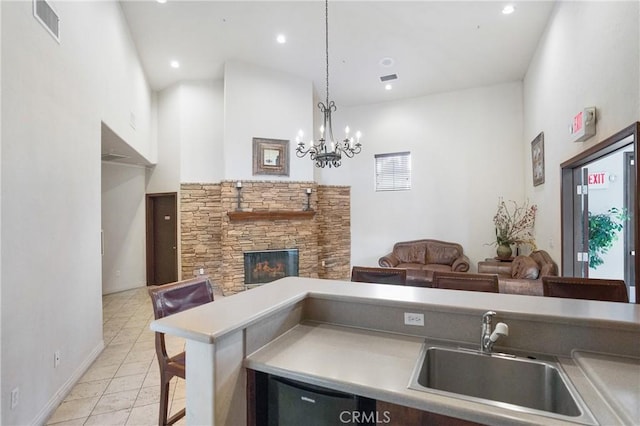 24909 Madison Ave Unit 1311, Murrieta, CA 92562 - kitchen with a sink, a high ceiling, a stone fireplace, and visible vents