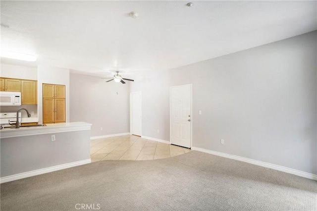 24909 Madison Ave Unit 1311, Murrieta, CA 92562 - unfurnished living room featuring a ceiling fan, light colored carpet, a sink, light tile patterned floors, and baseboards