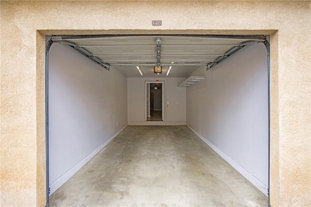 24909 Madison Ave Unit 1311, Murrieta, CA 92562 - garage with baseboards and a garage door opener