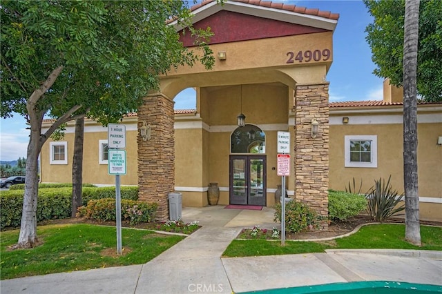 24909 Madison Ave Unit 1311, Murrieta, CA 92562 - doorway to property featuring a tiled roof, french doors, and stucco siding