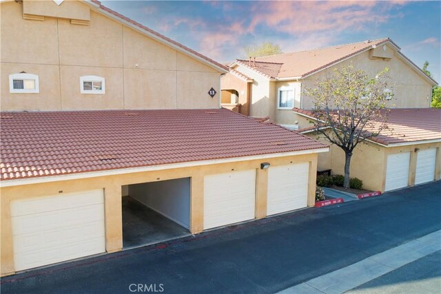 24909 Madison Ave Unit 1311, Murrieta, CA 92562 - exterior space with community garages, a tile roof, and stucco siding