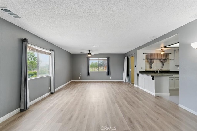 28755 Avenida Estrella, Menifee, CA 92587 - unfurnished living room with a ceiling fan, a textured ceiling, visible vents, and light wood-style flooring