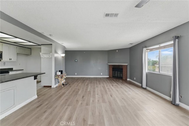 28755 Avenida Estrella, Menifee, CA 92587 - unfurnished living room featuring light wood-style floors, baseboards, a textured ceiling, and visible vents