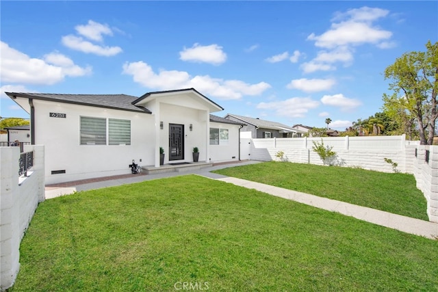 view of front facade with fence, stucco siding, and a front lawn
