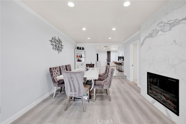 dining room featuring ornamental molding, light wood finished floors, and recessed lighting