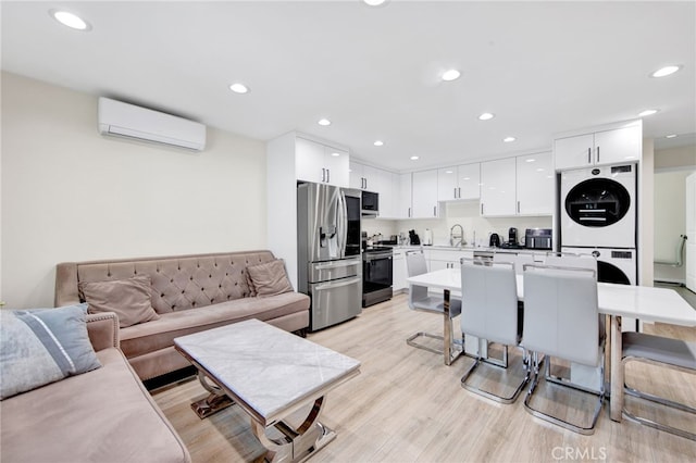living area featuring an AC wall unit, recessed lighting, stacked washer and clothes dryer, and light wood-type flooring