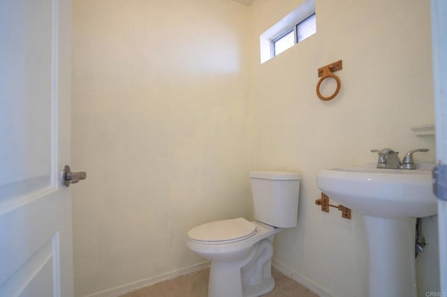bathroom featuring toilet and baseboards