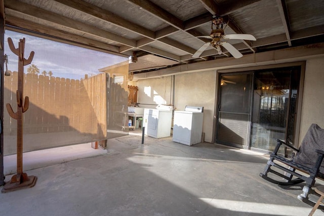 view of patio / terrace with a ceiling fan, washer and dryer, and fence