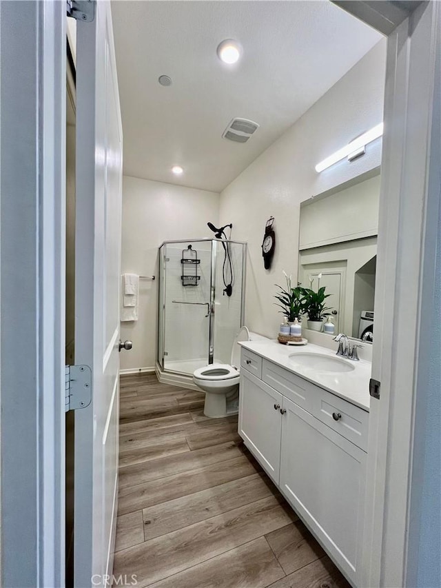 full bath with toilet, wood finished floors, vanity, visible vents, and a shower stall