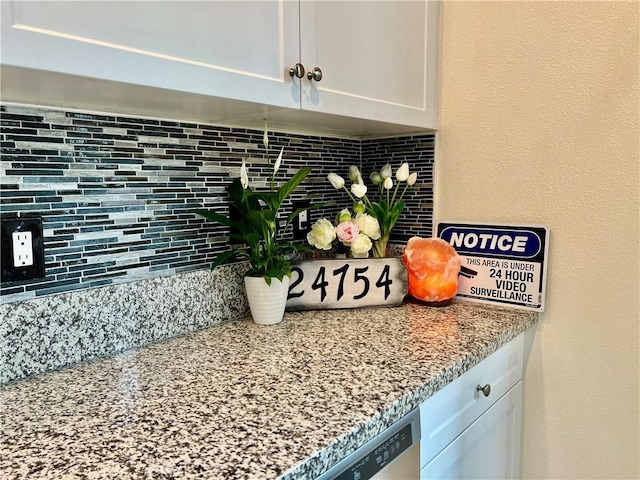 details with white cabinets, light stone counters, and tasteful backsplash