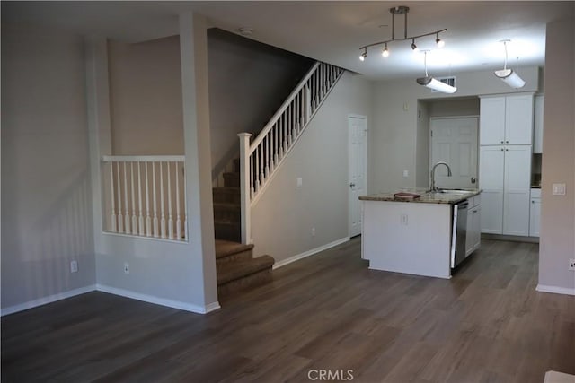 kitchen with white cabinets, a sink, baseboards, dishwasher, and dark wood finished floors