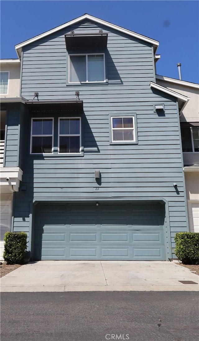 view of front facade with concrete driveway and a garage