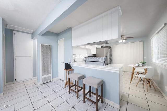 2430 Alexander St, Oxnard, CA 93033 - kitchen featuring ceiling fan, a heating unit, freestanding refrigerator, a peninsula, and light tile patterned floors