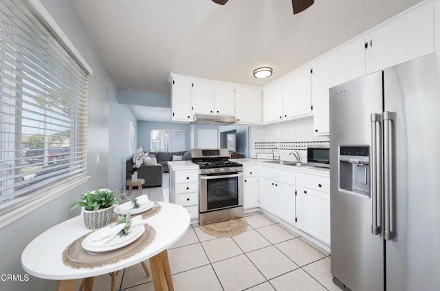 2430 Alexander St, Oxnard, CA 93033 - kitchen with stainless steel appliances, under cabinet range hood, ceiling fan, white cabinetry, and light tile patterned floors