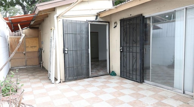 exterior space with a gate and stucco siding