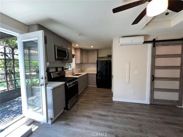 10709 Wheelock Cir, Whittier, CA 90606 - kitchen with stainless steel appliances, a wall mounted AC, a healthy amount of sunlight, and gray cabinetry