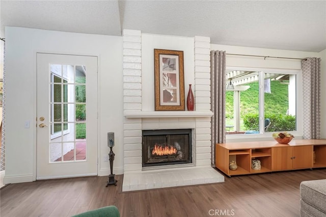 28143 Espinoza, Mission Viejo, CA 92692 - living area with a brick fireplace, a textured ceiling, baseboards, and wood finished floors