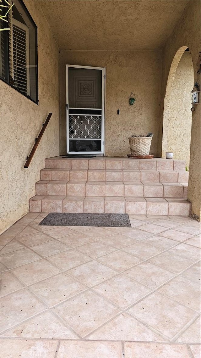 entrance to property featuring stucco siding