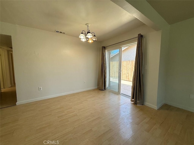 unfurnished room featuring light wood-style flooring, visible vents, baseboards, and a notable chandelier