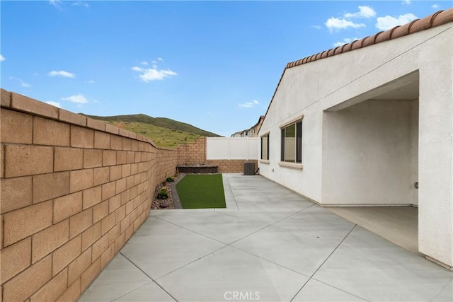 view of side of property with stucco siding, a fenced backyard, and a patio area