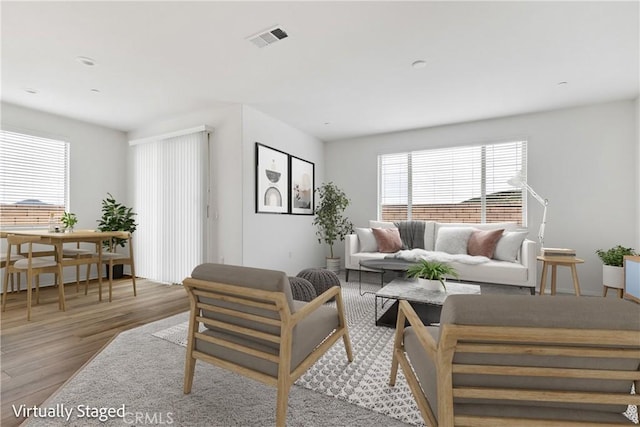 living area featuring visible vents, wood finished floors, and plenty of natural light