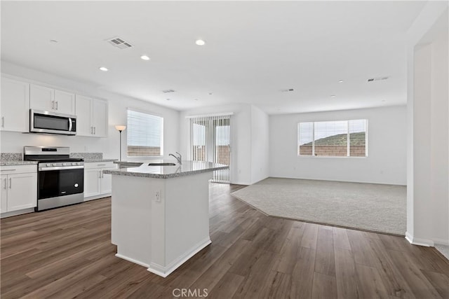kitchen with open floor plan, visible vents, stainless steel appliances, and plenty of natural light