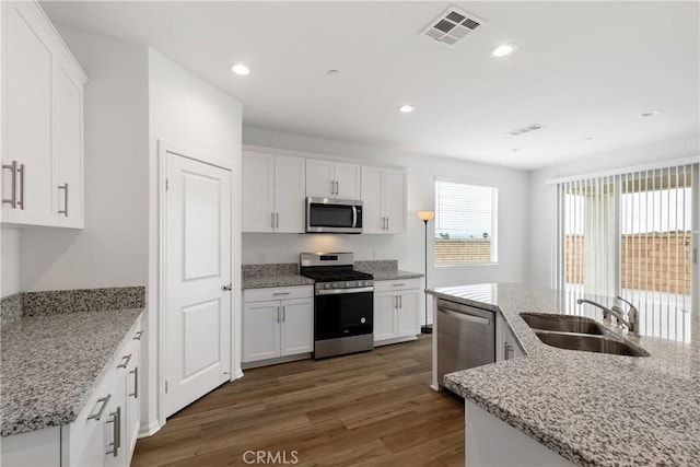 kitchen with stainless steel appliances, dark wood-style flooring, a sink, white cabinetry, and visible vents