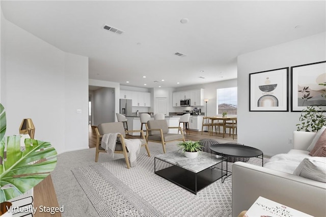 living room featuring visible vents, light carpet, and recessed lighting